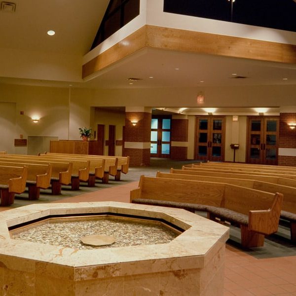 Interior of Lamb of God Lutheran Church located in Flower Mound, TX with Upholstered Seat and Wood Back Pews