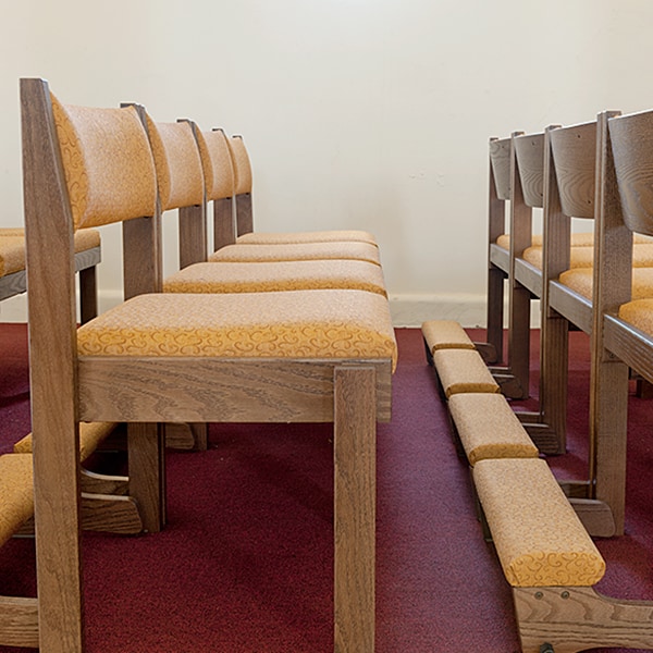 Side View of Chairs and Kneelers with Yellow Fabric in St. Raphael Church located in Koloa, HI