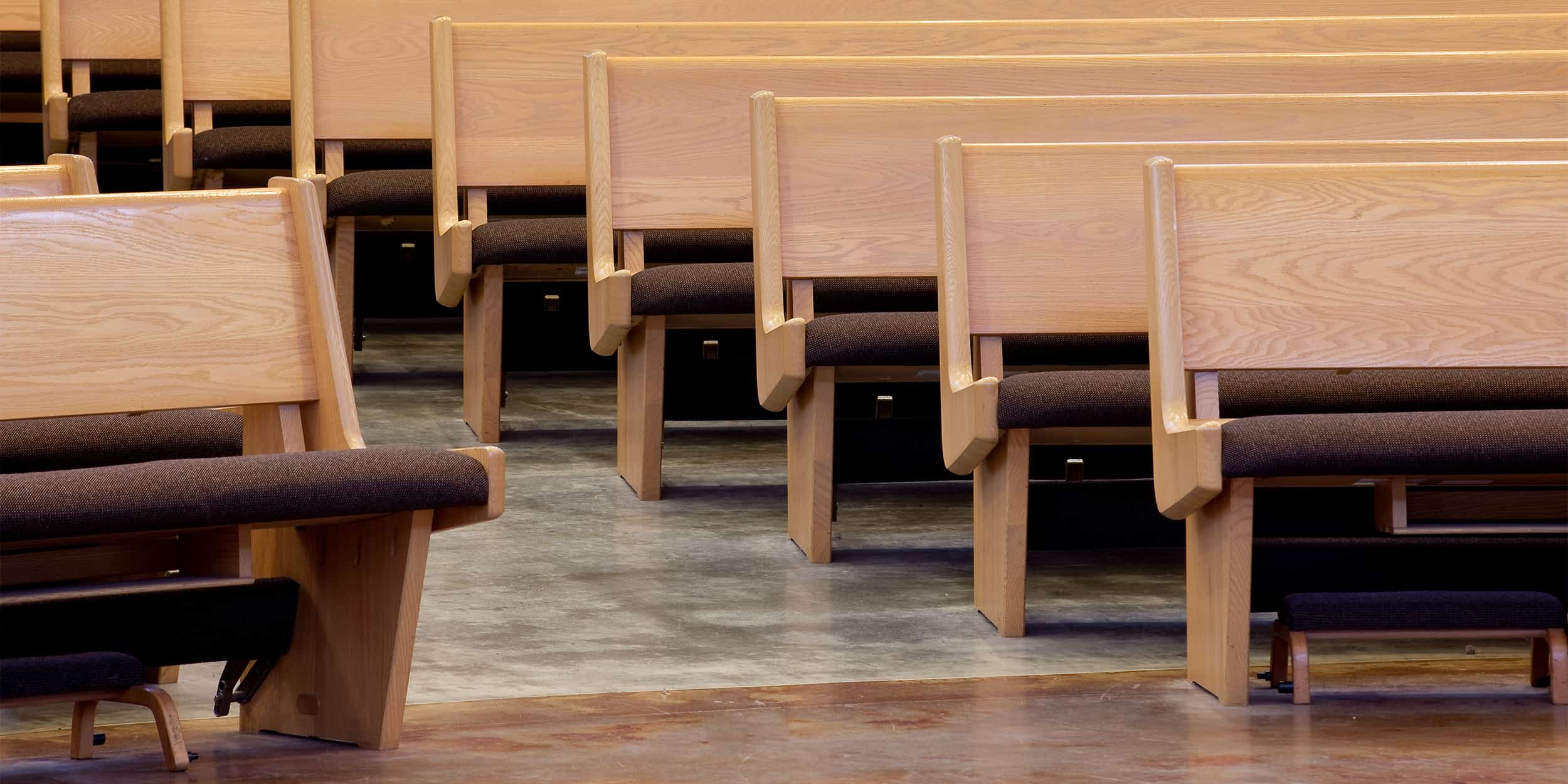 Sauder Church Pews with upholstered seat and wood back.